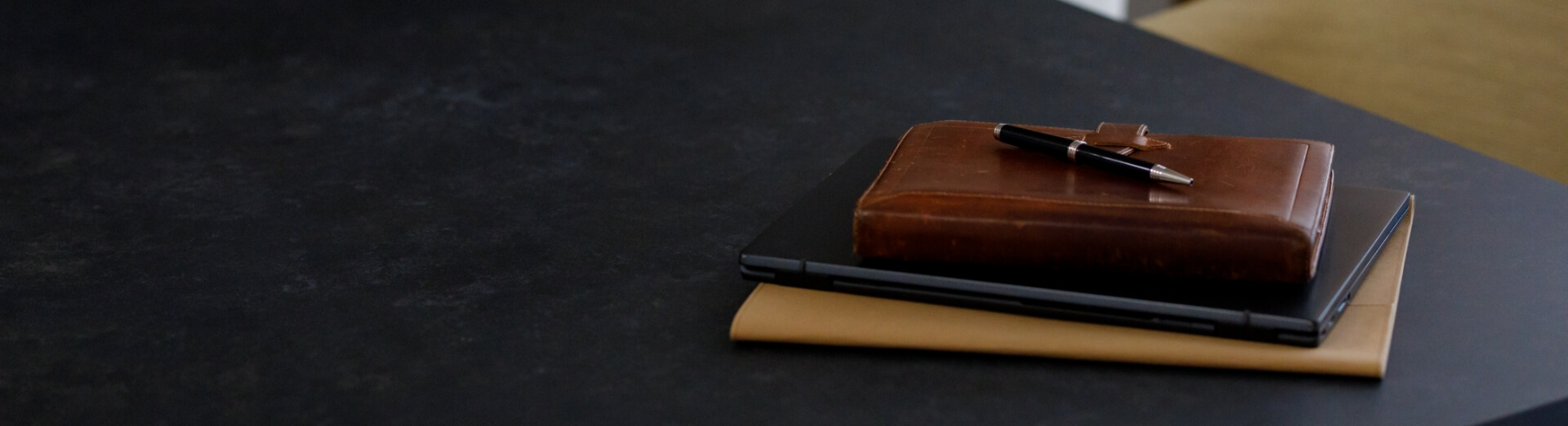 茶色いカバーの手帳とPCとペン